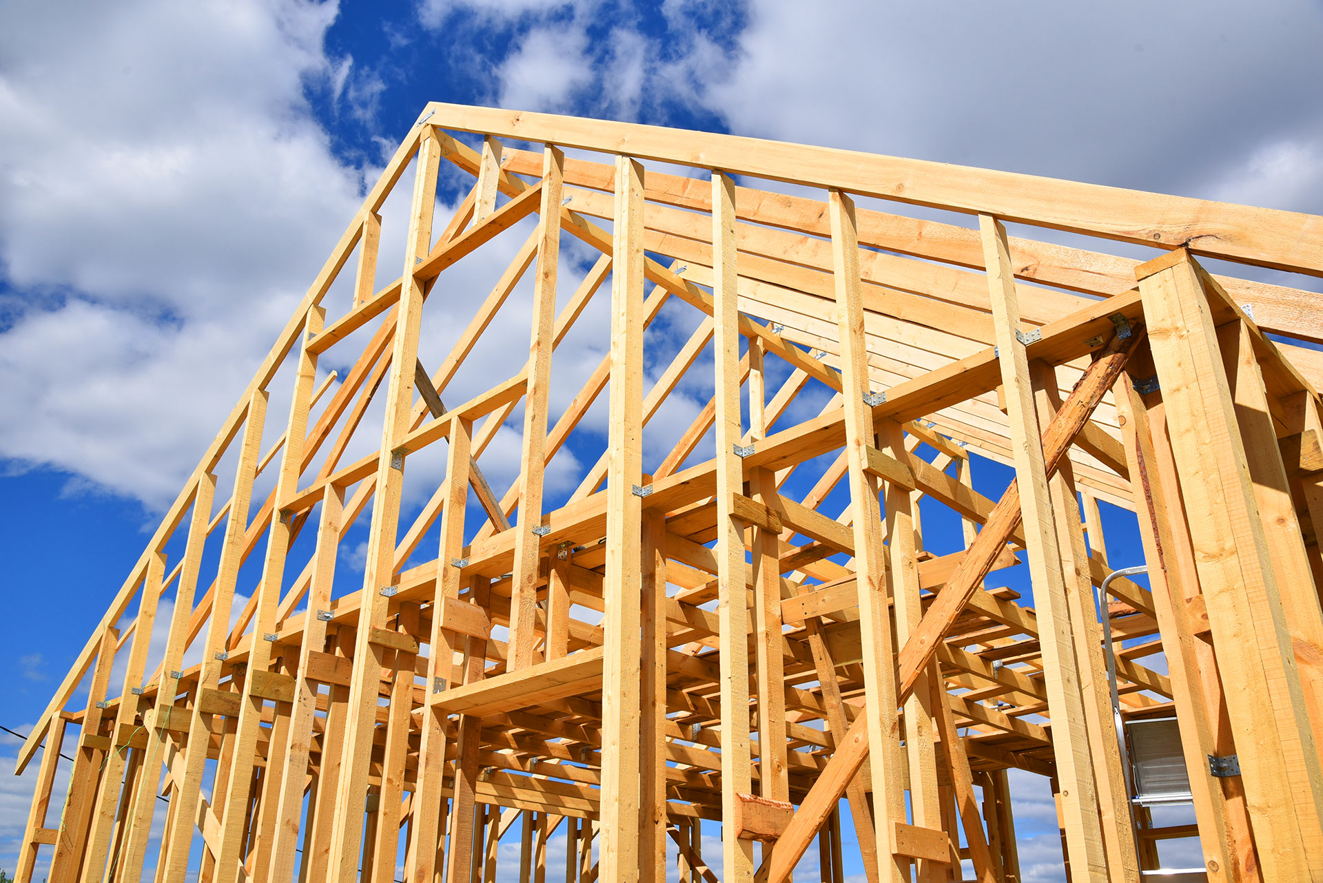 Wooden house frame construction against blue sky